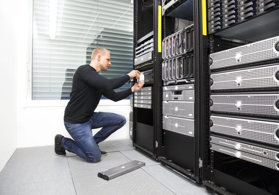 It engineer or technician maintaning storage area network SAN in data rack. Shot in datacenter.