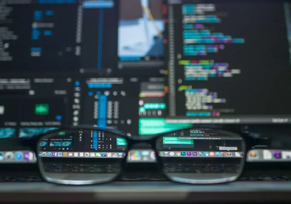 Here's a short alt tag for the image: `Code reflected in glasses on laptop.`